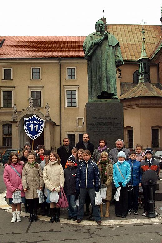 Pamiątkowa fotografia pod pomnikiem na placu Wszystkich Świętych w Krakowie.