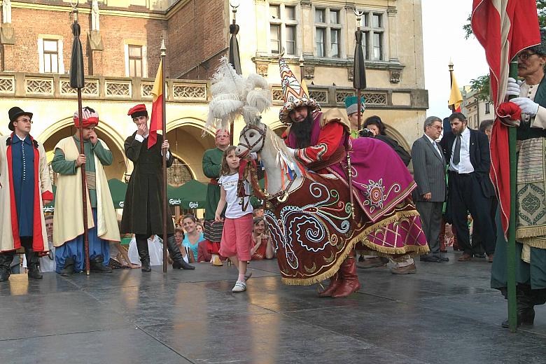 Harcujący Lajkonik na scenie przed Wieżą Ratuszową.