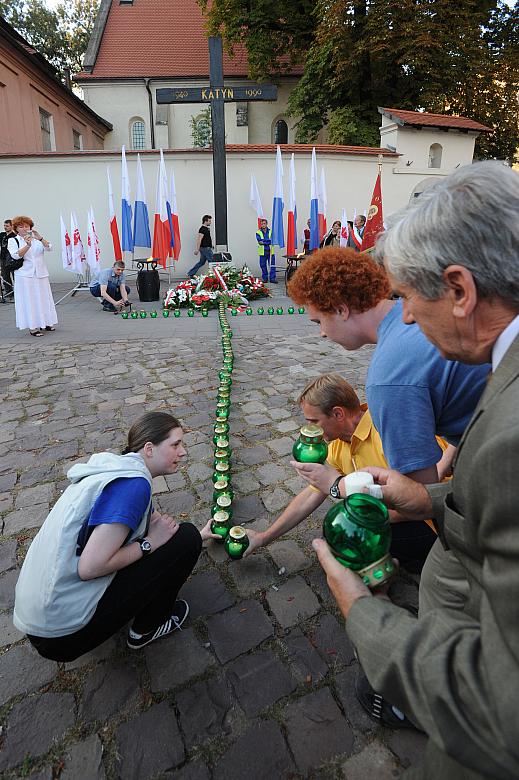 ... krzyż z zapalonych zniczy.